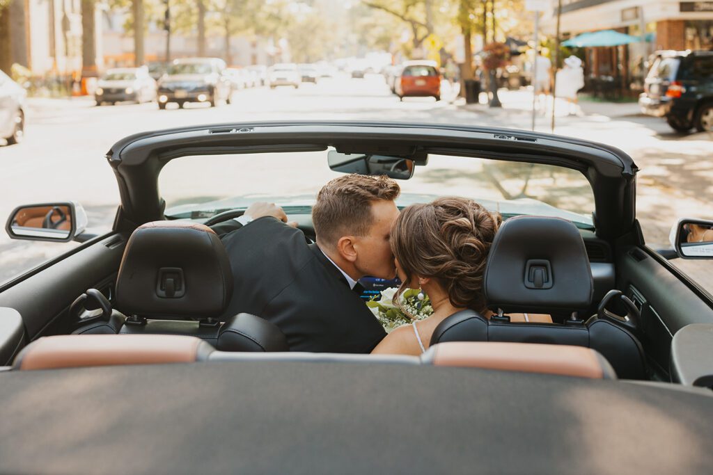 Bride and groom in a convertible car