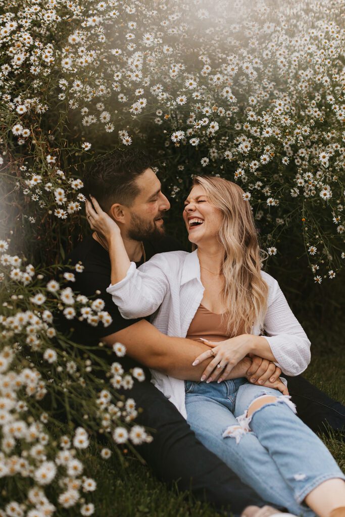 playful couples photo in a field of daisies