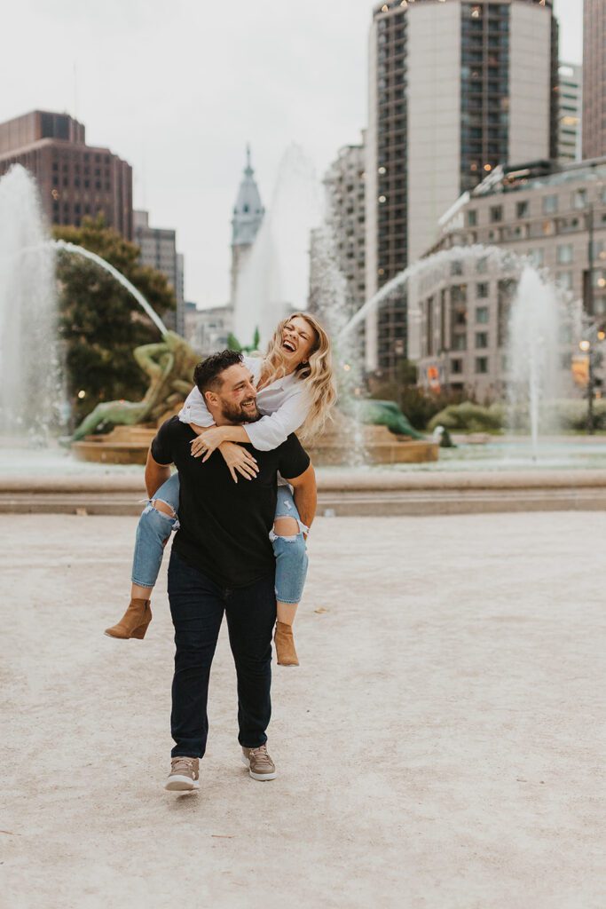 playful Philadelphia engagement photo with a fountain in the backdrop