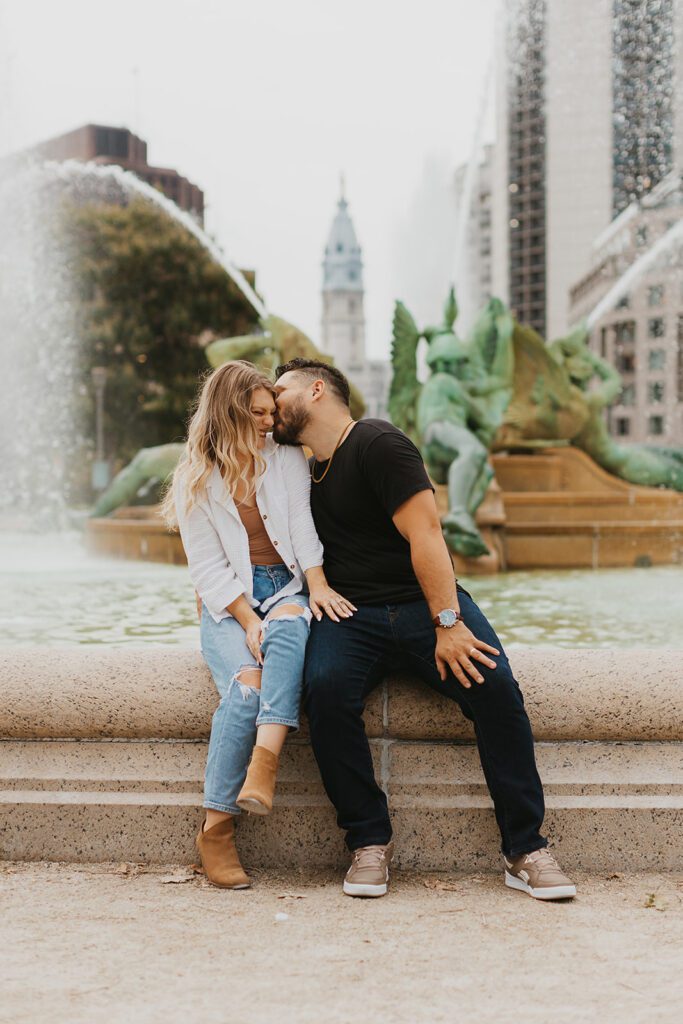 playful Philadelphia engagement photo with a fountain in the backdrop