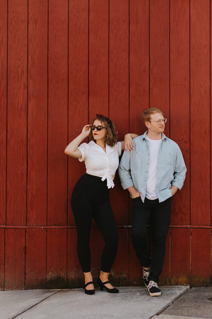 playful engagement photo by a red brick wall