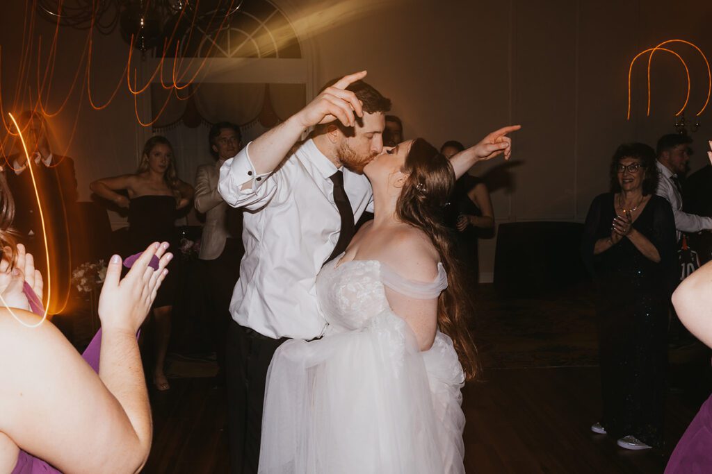 Energetic dance floor scene at a Jewish wedding, set in the luxurious grounds of a country club