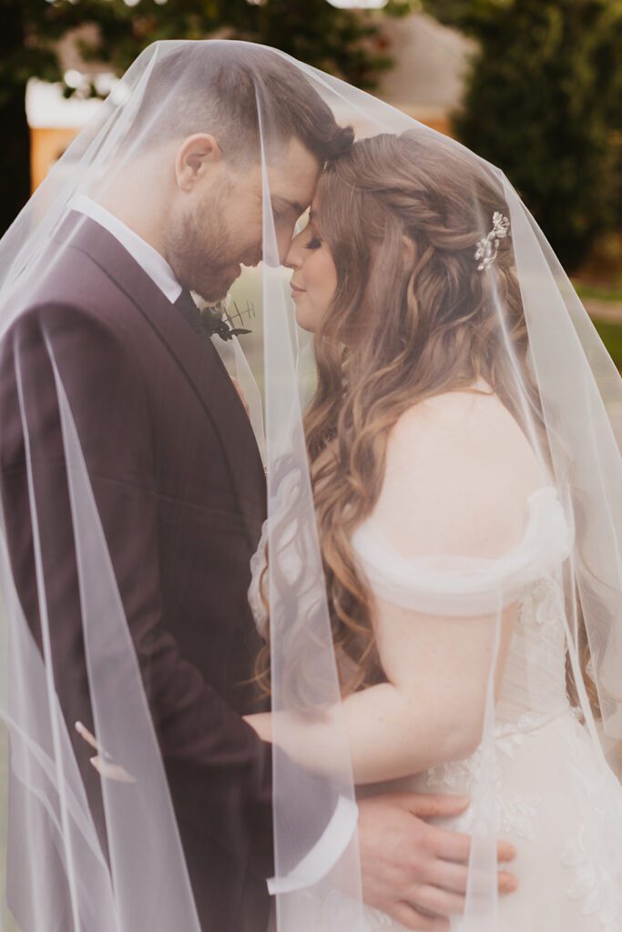 Bride and groom intimate under the veil portrait