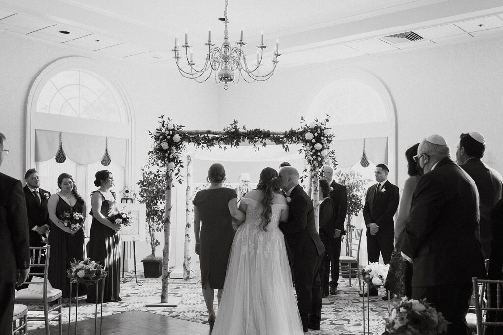 Intimate moment during a Jewish wedding ceremony, held at a picturesque country club venue
