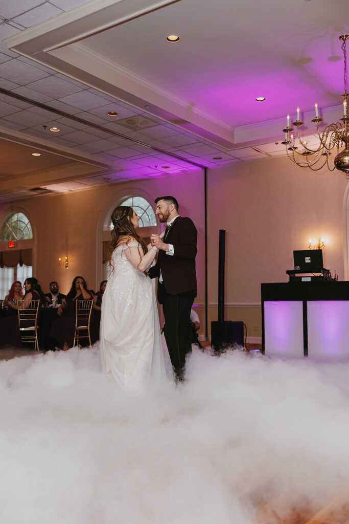 Bride and groom sharing a tender first dance, celebrating their union at a Jewish wedding in a country club