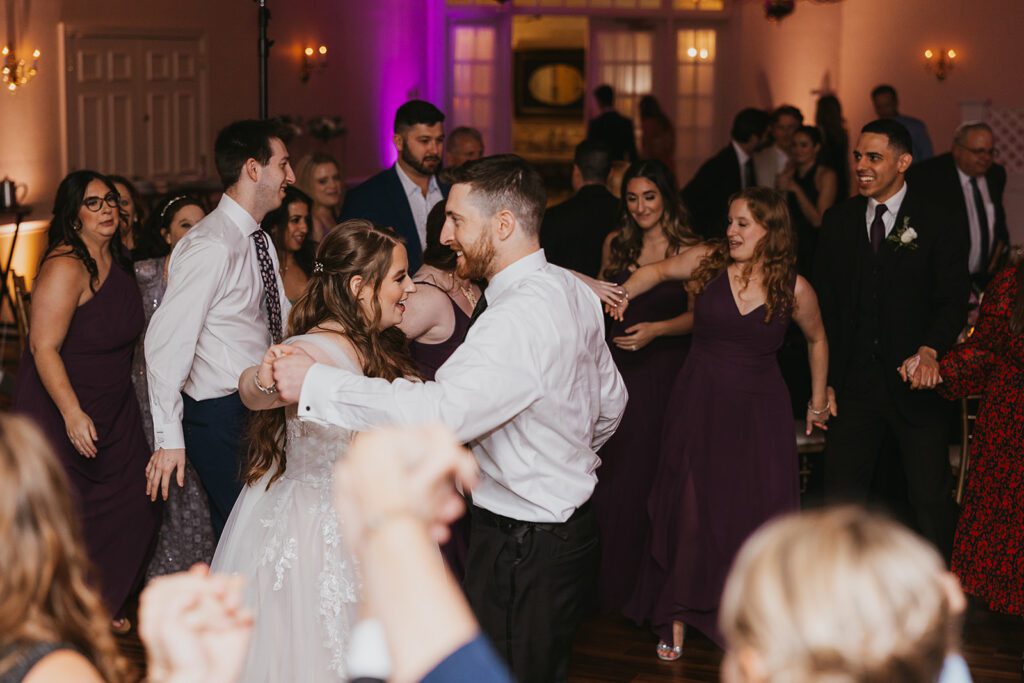 Joyful dancing at a Jewish wedding reception held at a The Spring Hill Manor, a country club wedding venue