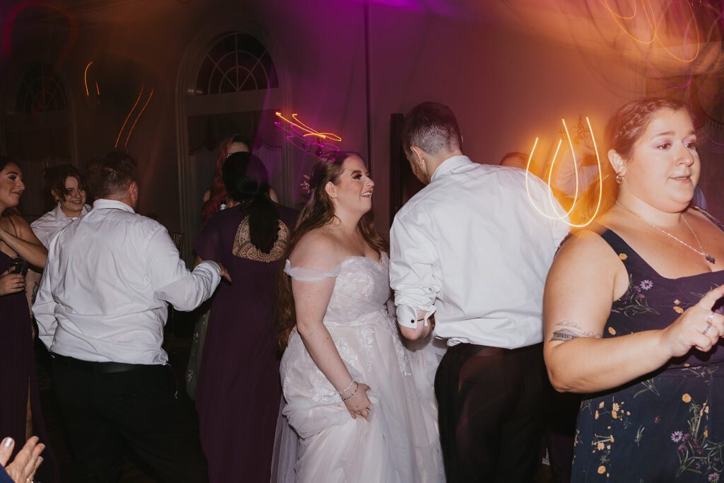 Energetic dance floor scene at a Jewish wedding, set in the luxurious grounds of a country club