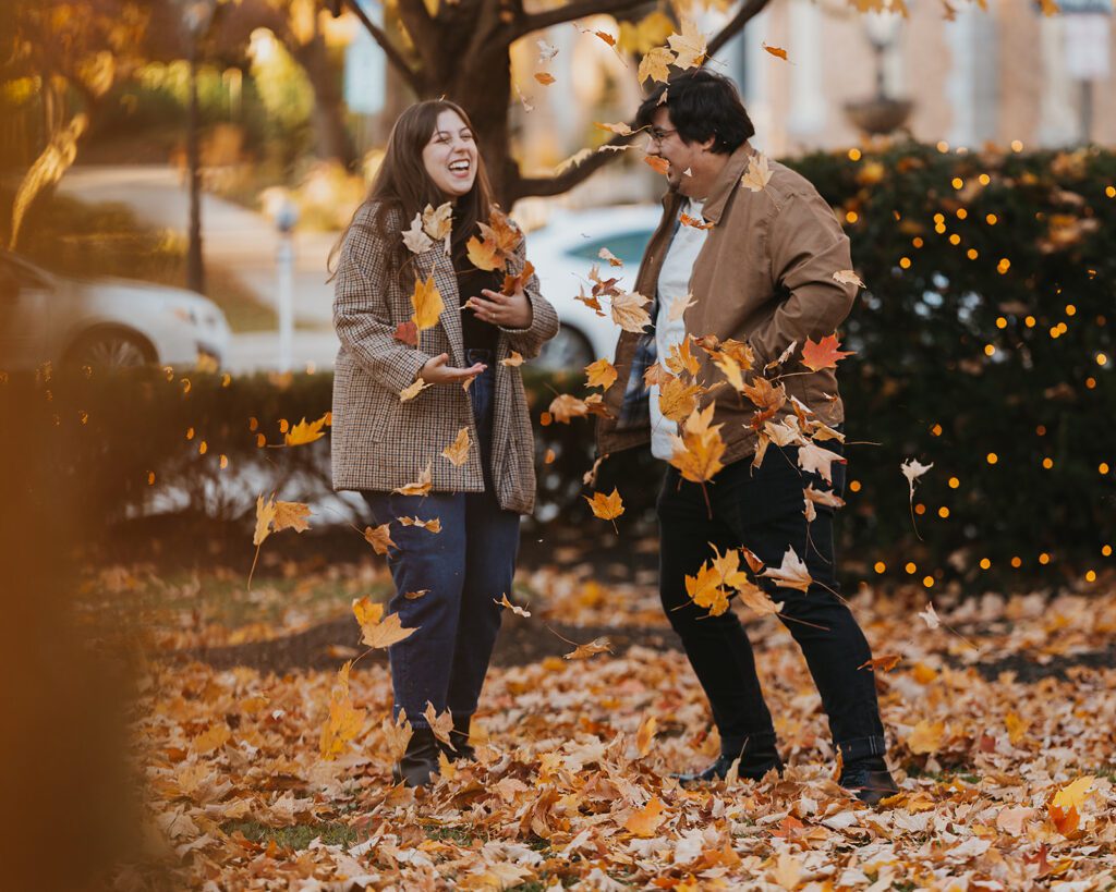 A delightful shot of Alexa and Joe playfully chasing each other through the leafs, embodying the joy and playfulness of their engagement in the fall season.