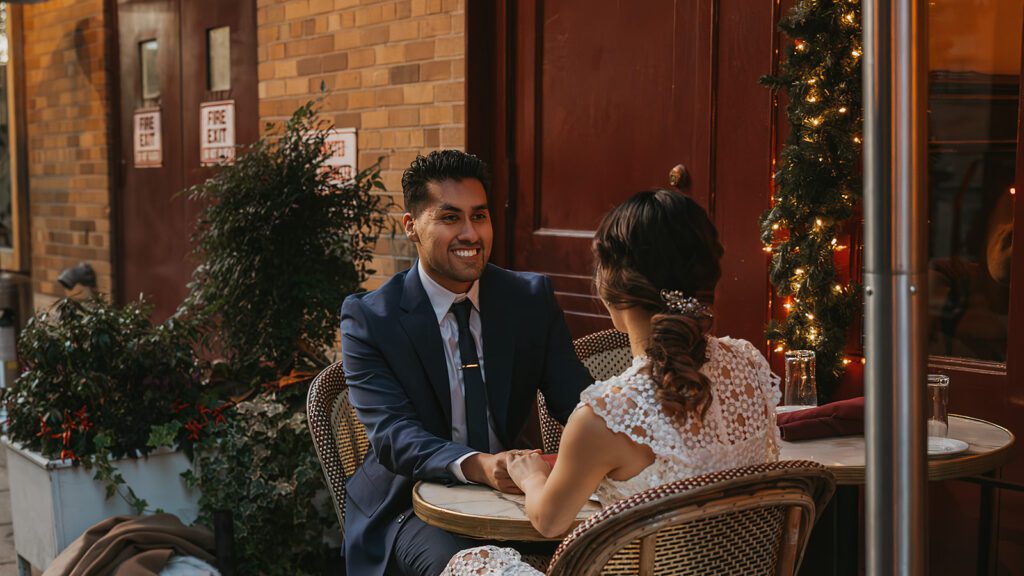 Megan and Luis laughing together during their engagement photo session at Parc in Rittenhouse Square