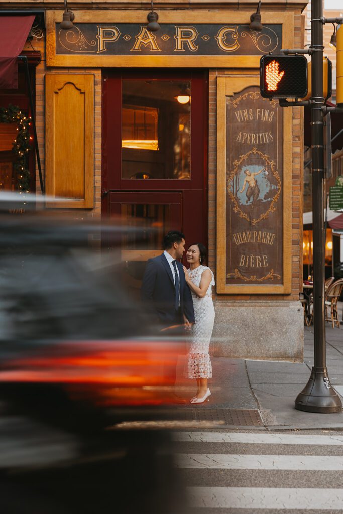 An intimate snapshot of Megan and Luis standing in front of Parc, Rittenhouse Square, immersed in conversation