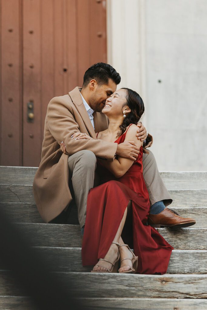A candid shot of the couple cuddling near the Second Bank, with the classic architecture providing an elegant backdrop.