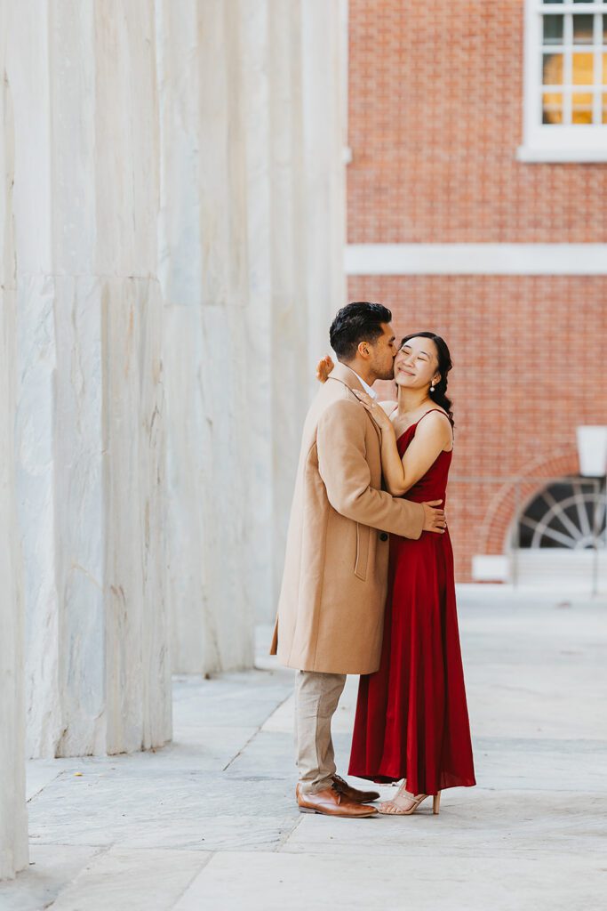 A candid shot of the couple cuddling near the Second Bank, with the classic architecture providing an elegant backdrop.