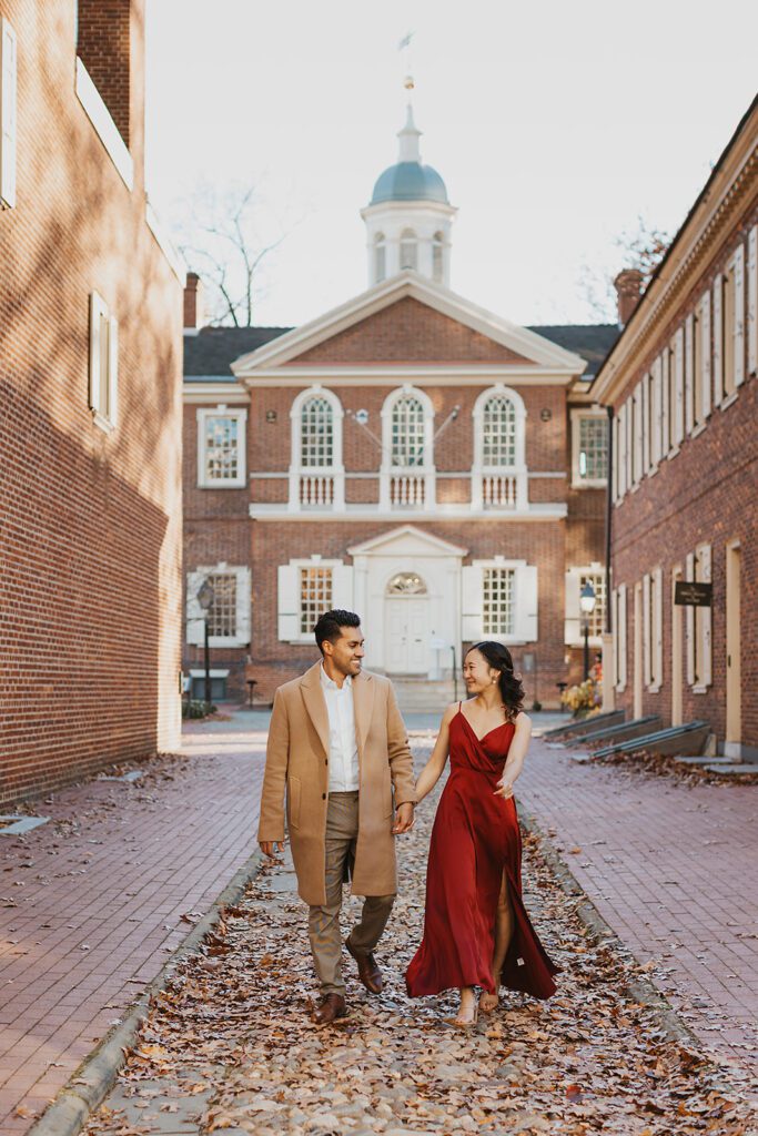 Megan and Luis holding hands and walking through the streets of Old City, Philadelphia