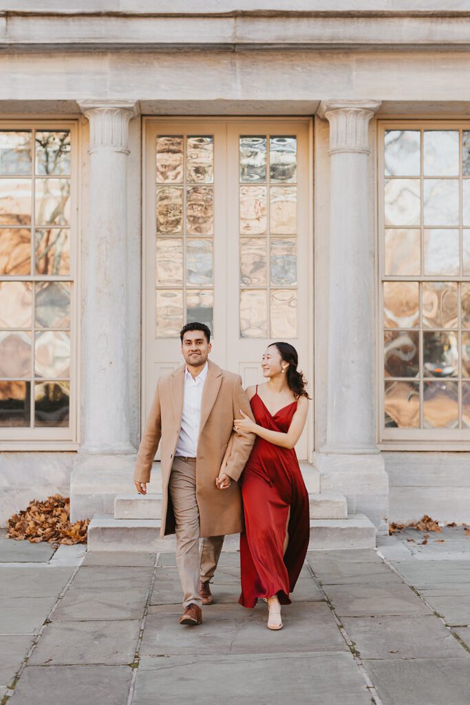 Megan and Luis holding hands and walking around for their Old City Philadelphia engagement photos