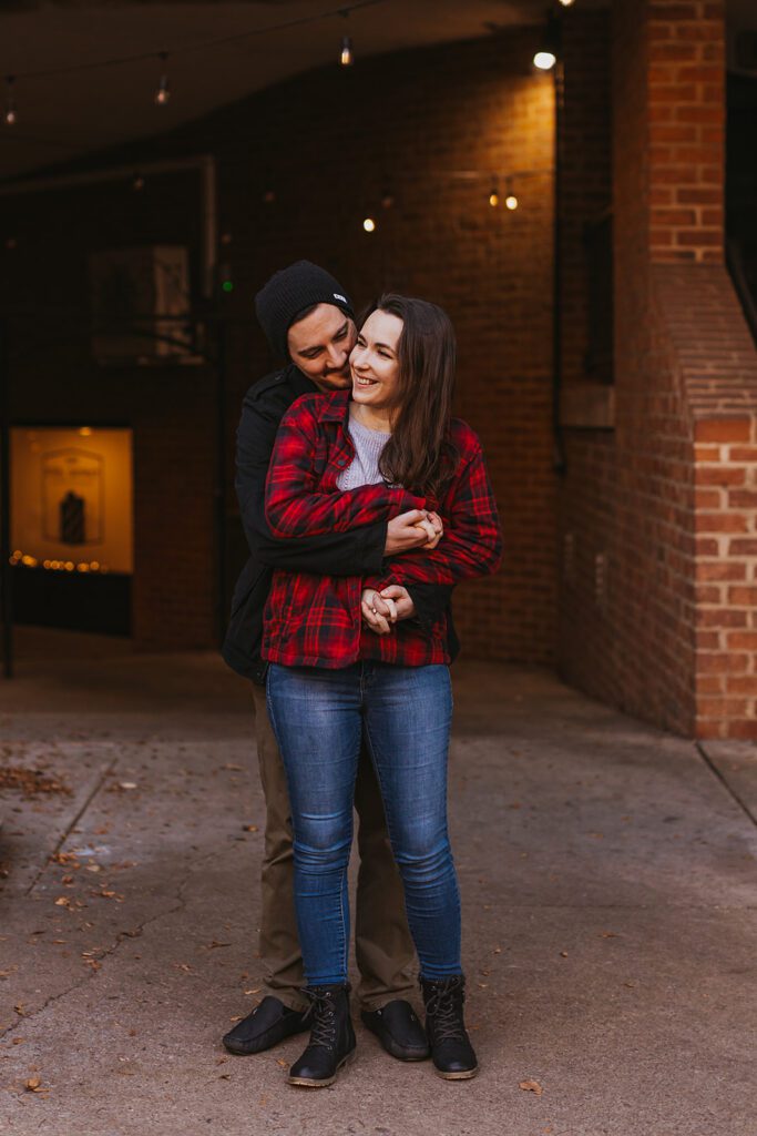 Engagement photo capturing Christine and Joe's playful spirit as they enjoy a moment together in the heart of downtown, embodying the essence of their urban engagement session