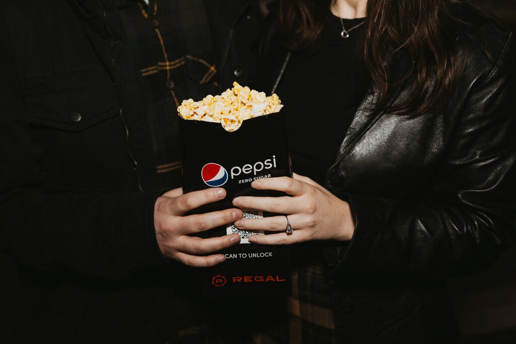 close up of couple holding a box of popcorn