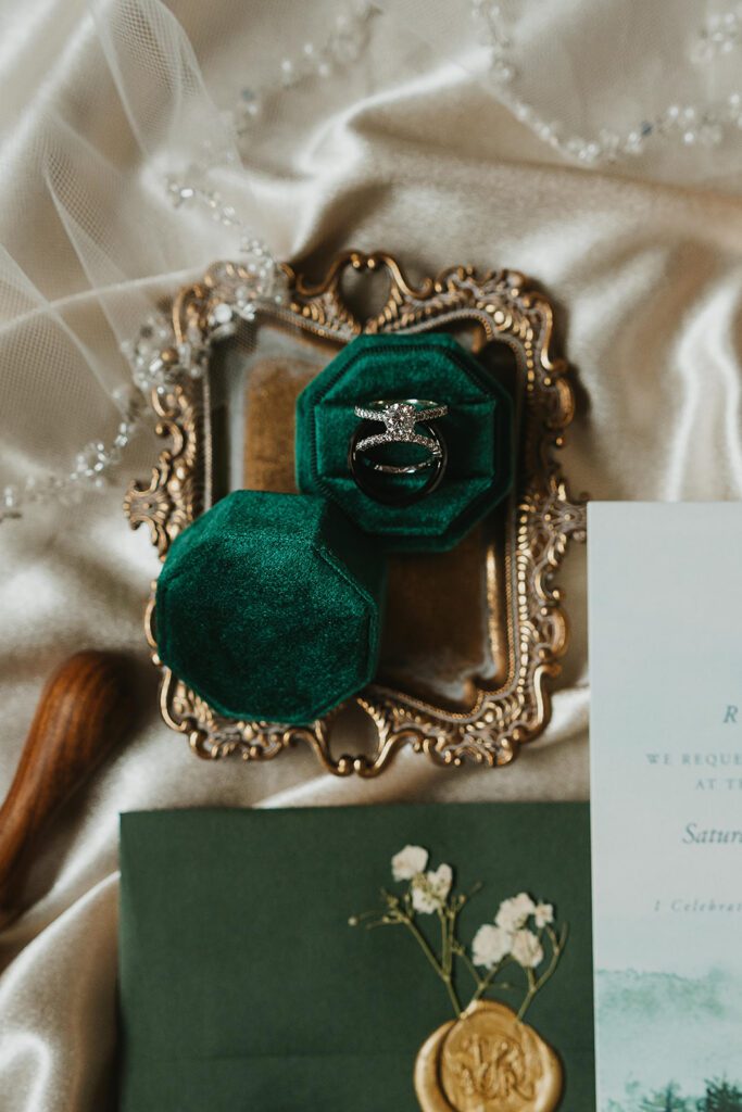 elegant winter wedding detail flatlay featuring dark greens, gold and silver 