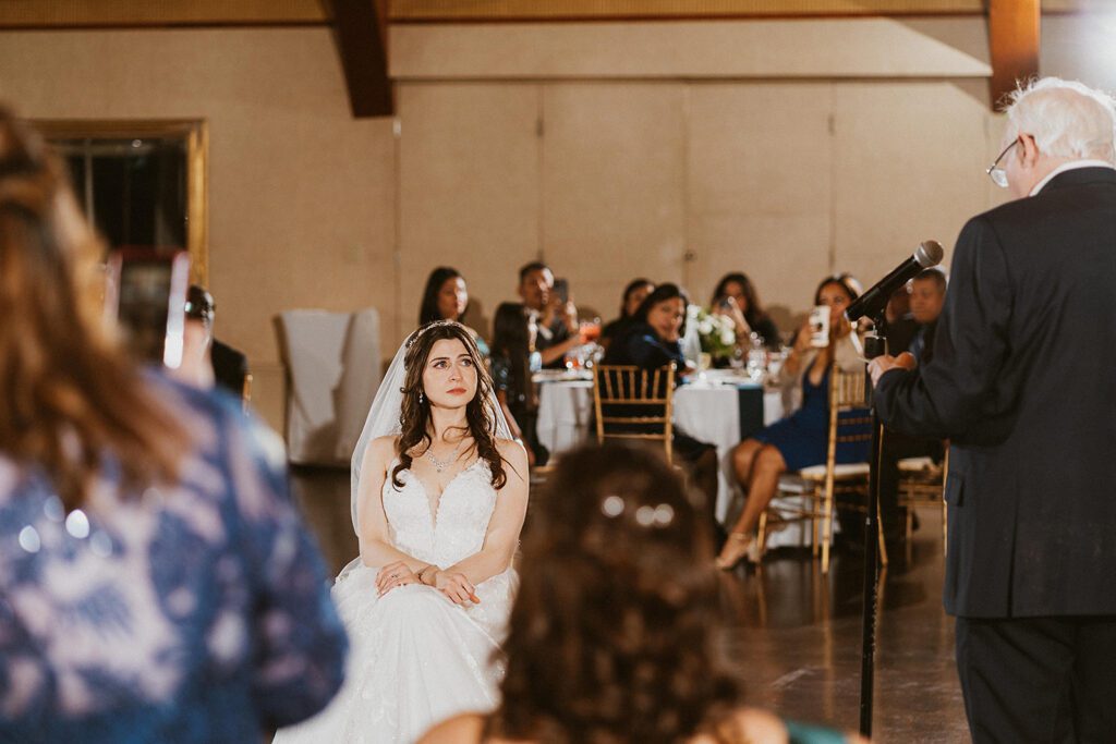 dad reading his daughter, the bride, her childhood favorite book during his wedding speech