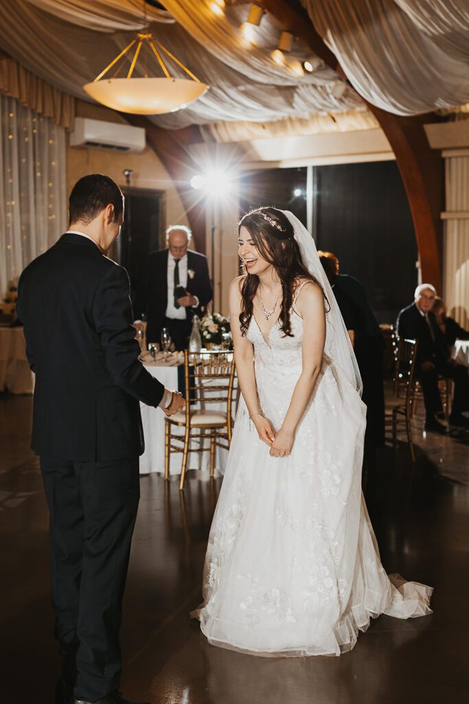 bride and groom having fun during their wedding reception in an elegant ballroom in birch hill estates
