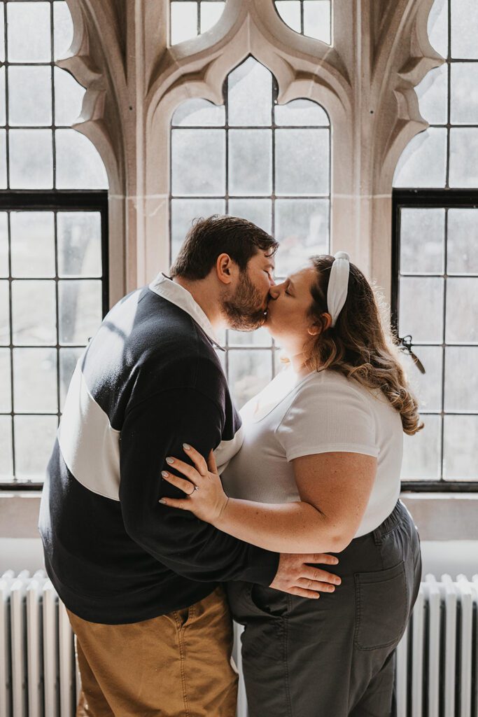 romantic engagement photos by a vintage window at Lehigh University Library