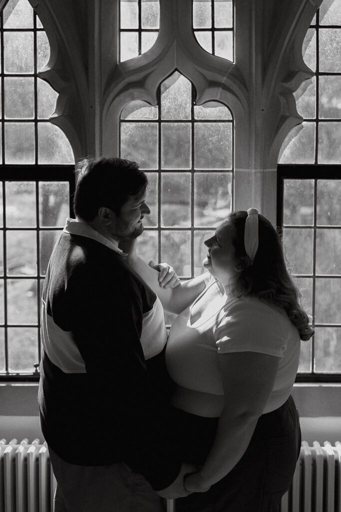romantic engagement photos by a vintage window at Lehigh University Library