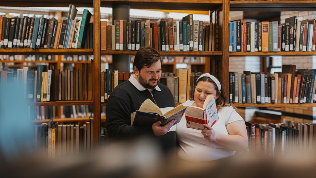 couple reading books together during their library engagement session at Lehigh University