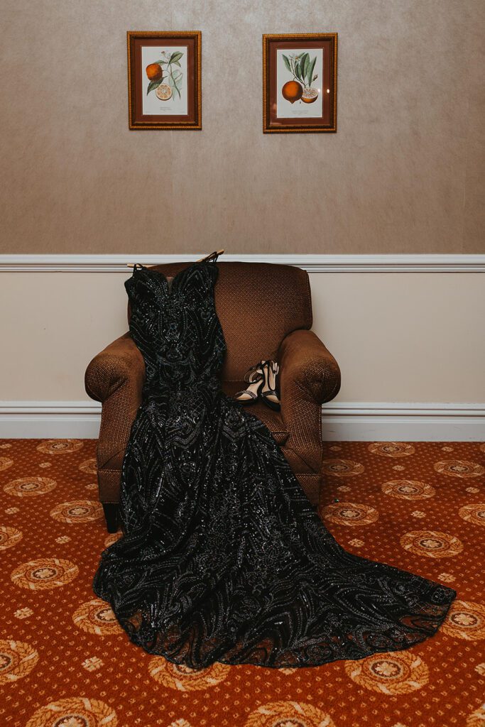 elegant black wedding dress laid over a chair