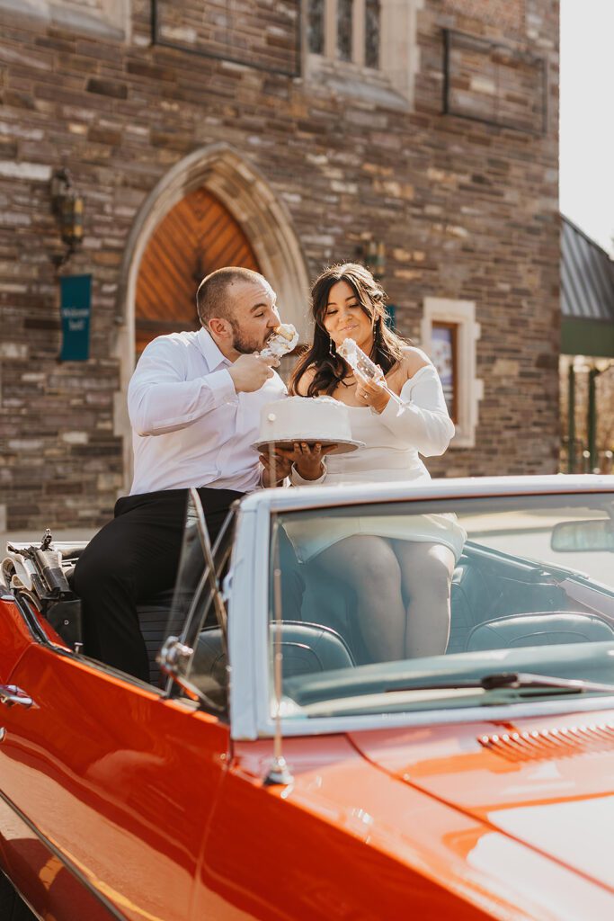 couple eating cake together sitting in a vintage convertible