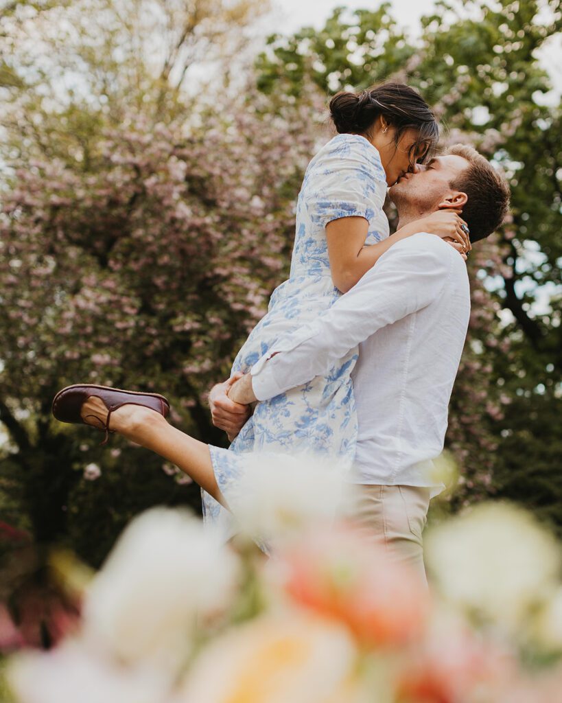 candid engagement photos in cherry blossoms