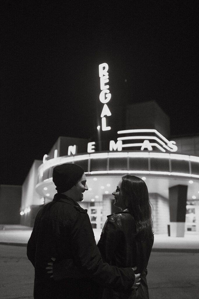 a sweet couple gazing upon a vintage movie theater