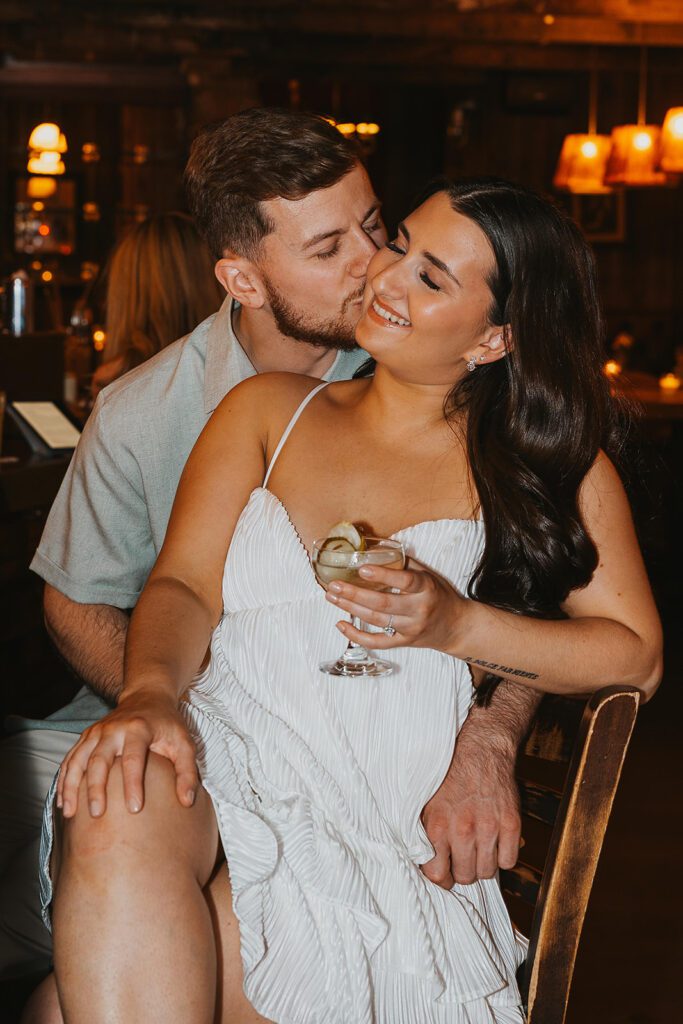 newly engaged couple enjoying drinks at a bar