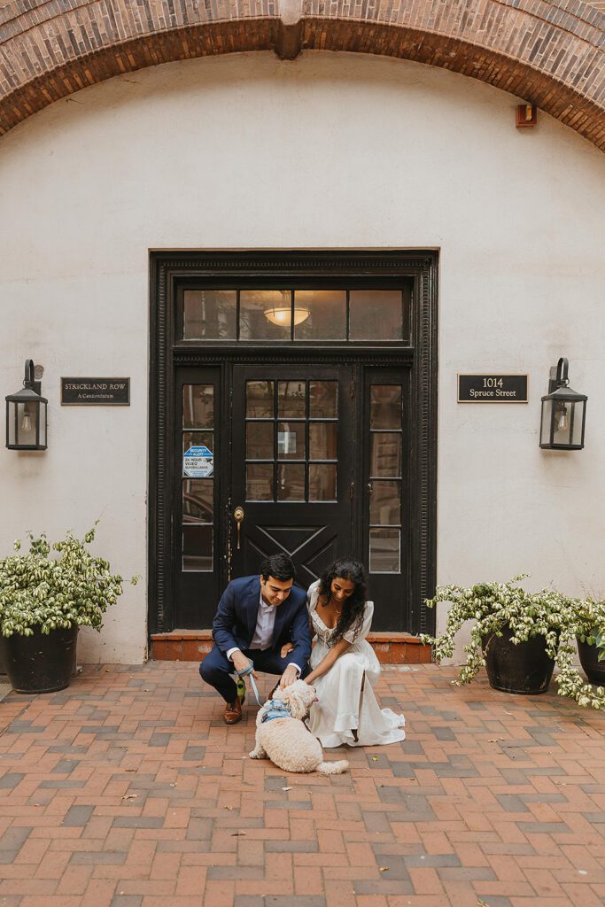 engaged couple cuddling their dog during their candid engagement photos