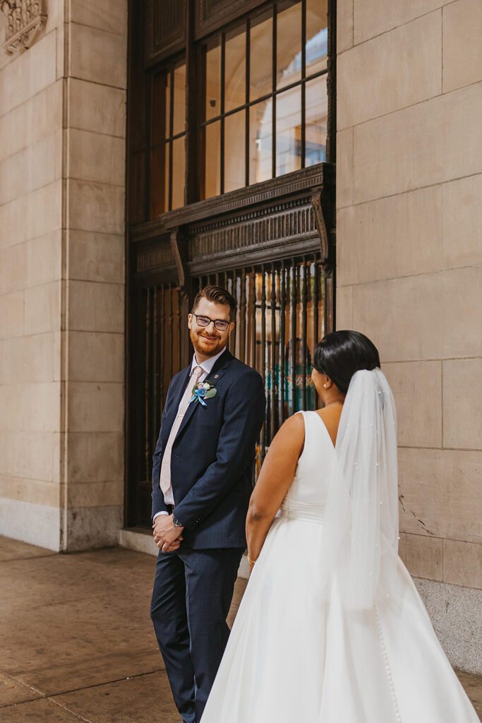 bride and groom first look in downtown Philadelphia surrounded by elegant architecture