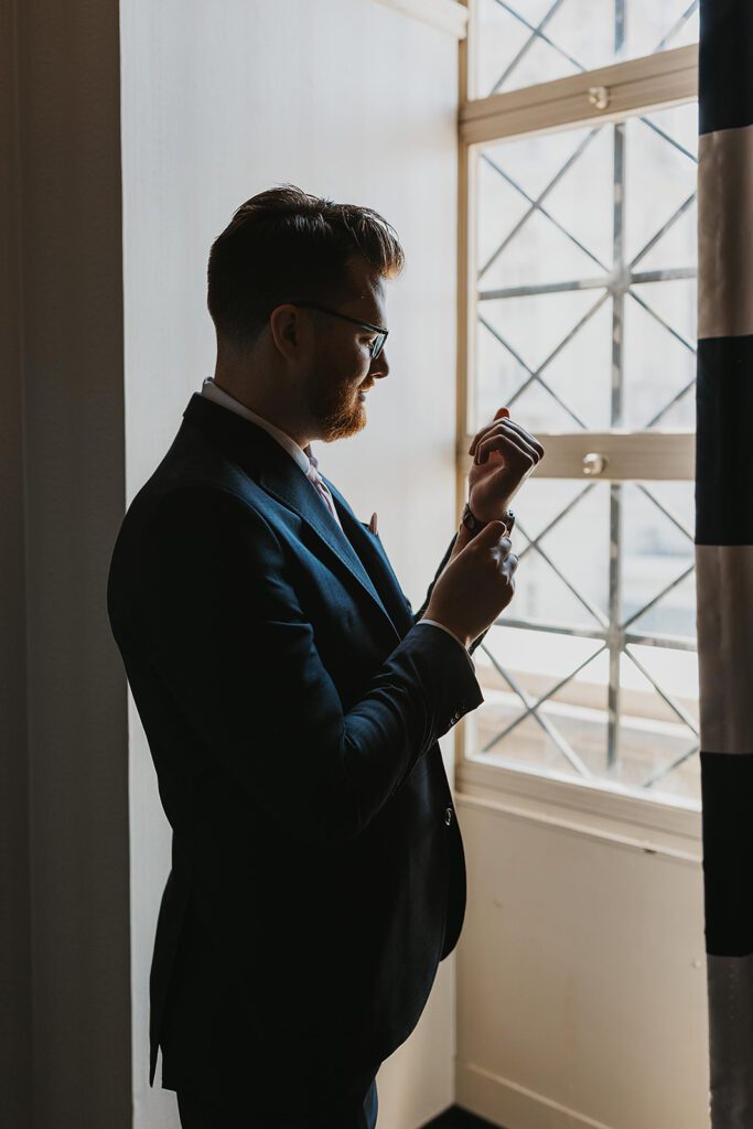 groom getting ready portraits by the window