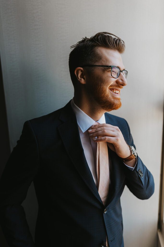 groom getting ready portraits by the window