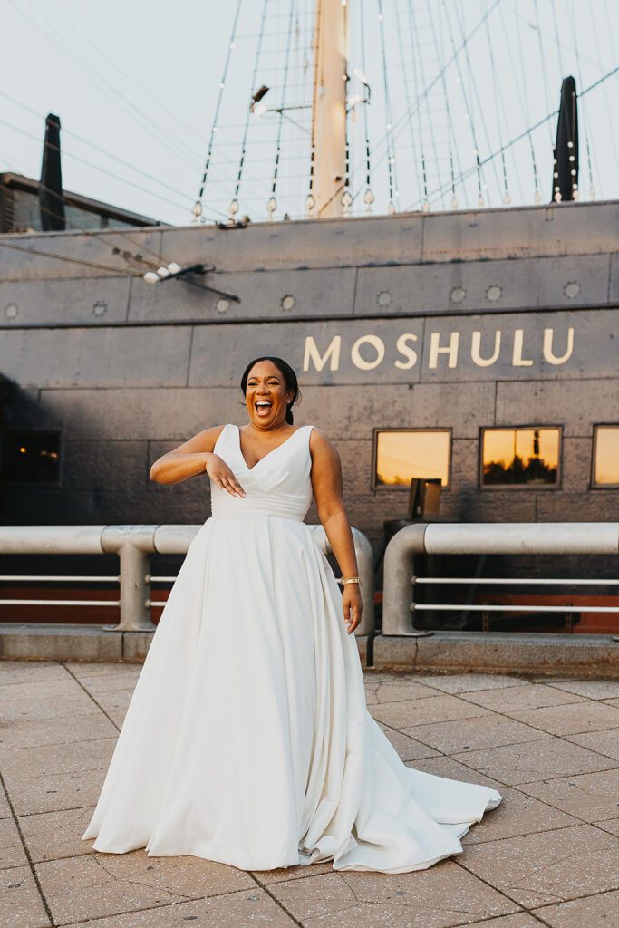 happy bride in an elegant dress with a ship in the backdrop