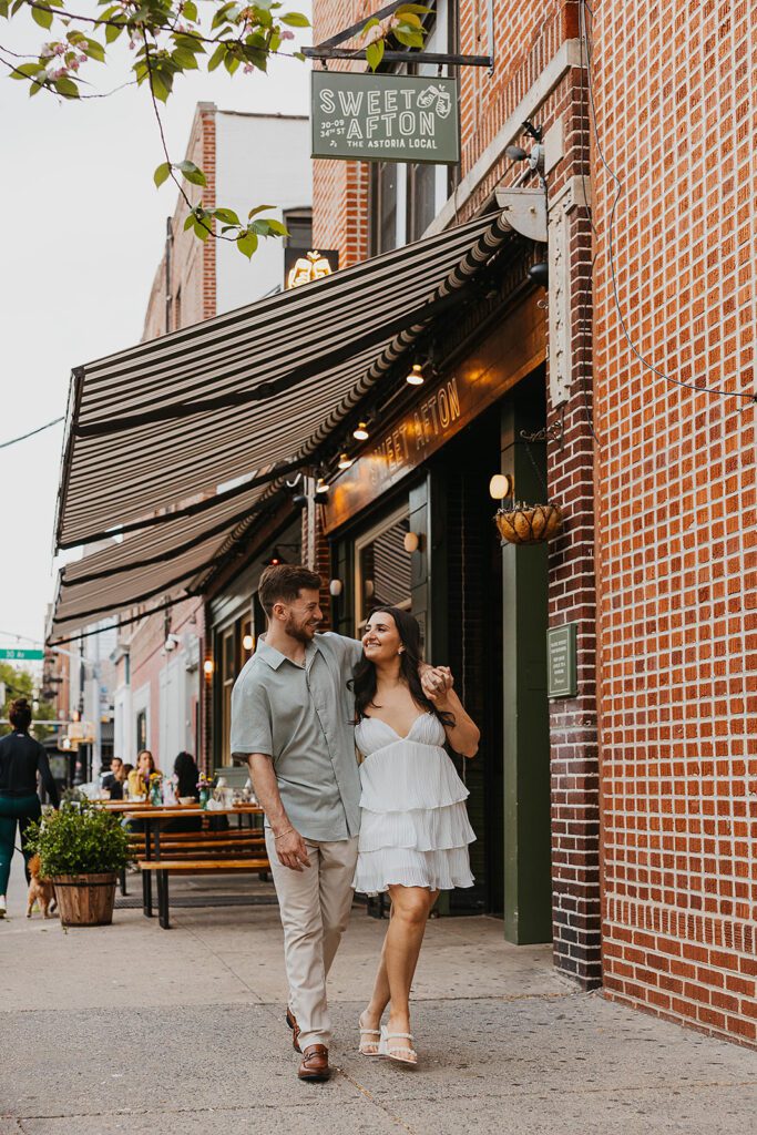 couple walking down the street by Sweet Afton bar