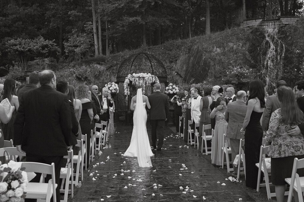 black and white shot of dad walking bride down the aisle