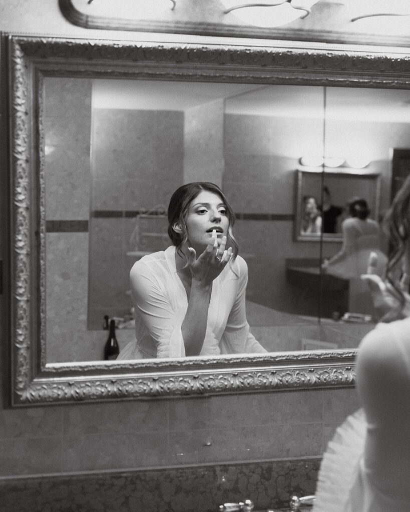 bride getting ready at the mirror