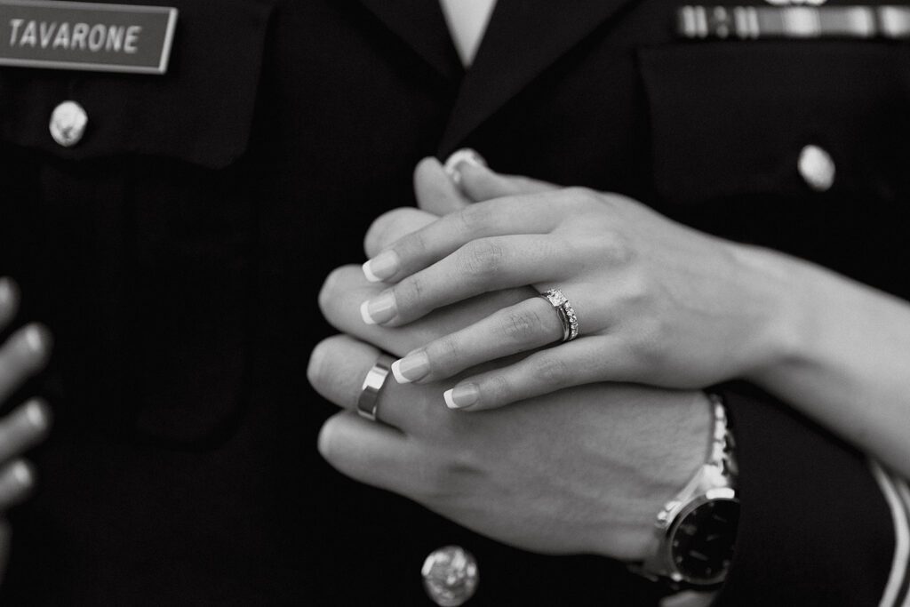 close up of bride and groom holding hands and wedding rings