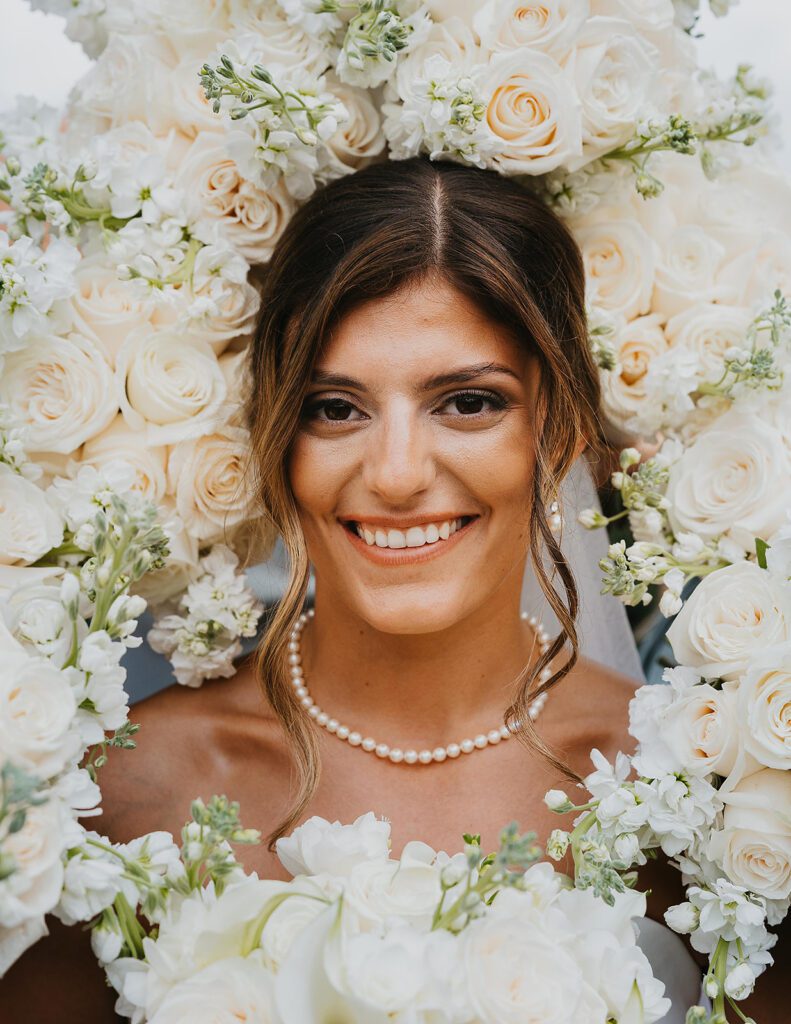 Bride surrounded by light bridesmaid bouquets